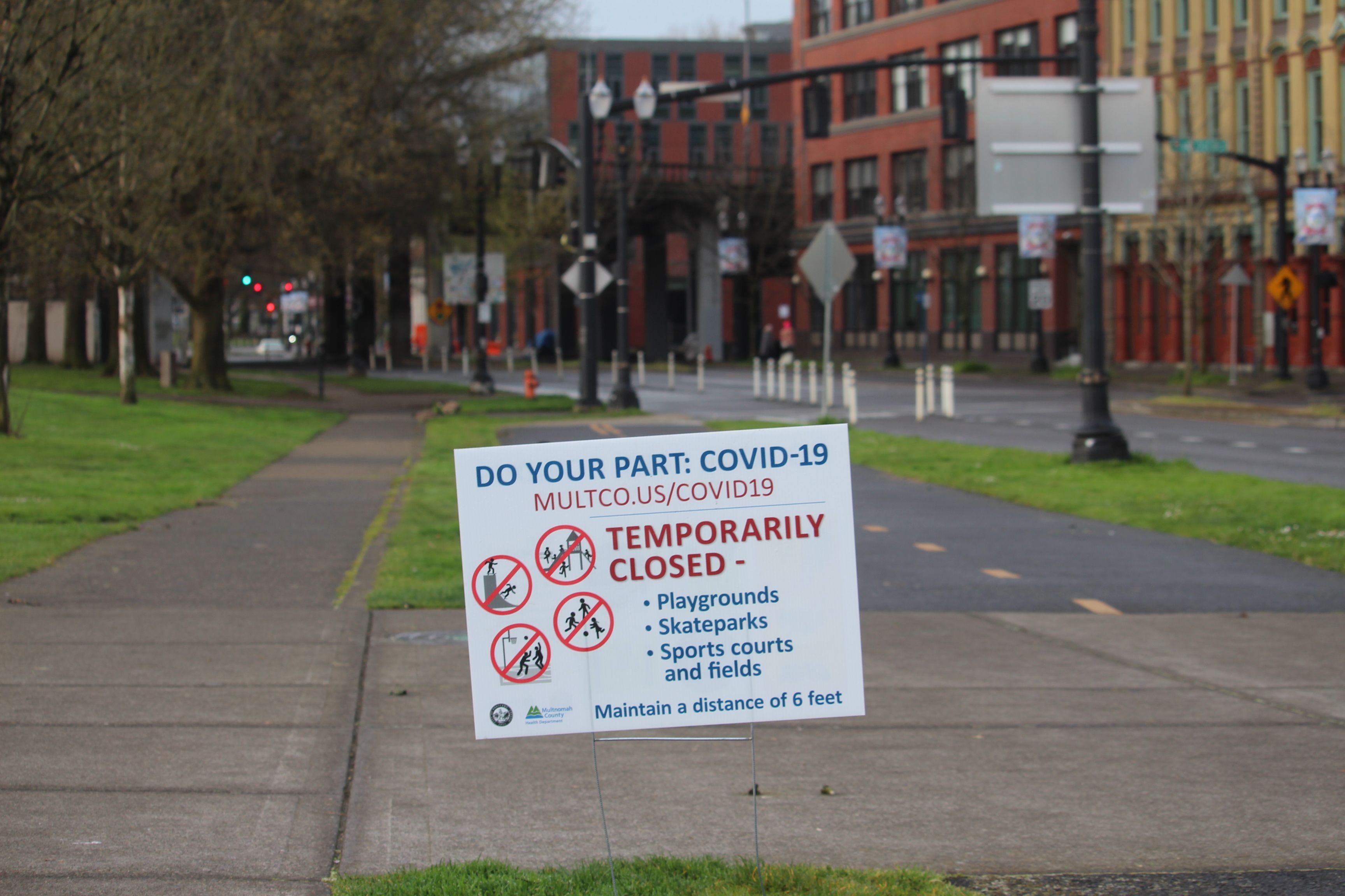 April 5, 2020 – A sign posted by Multnomah County informs citizens that parks and playgrounds are closed and reminds individuals to maintain a distance of six feet between each other. Image by Sarah Fahmy. United States, 2020.
