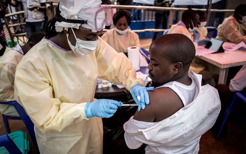A health worker in Katwa vaccinates a man against Ebola. Image by John Wessels. Democratic Republic of Congo, 2019.