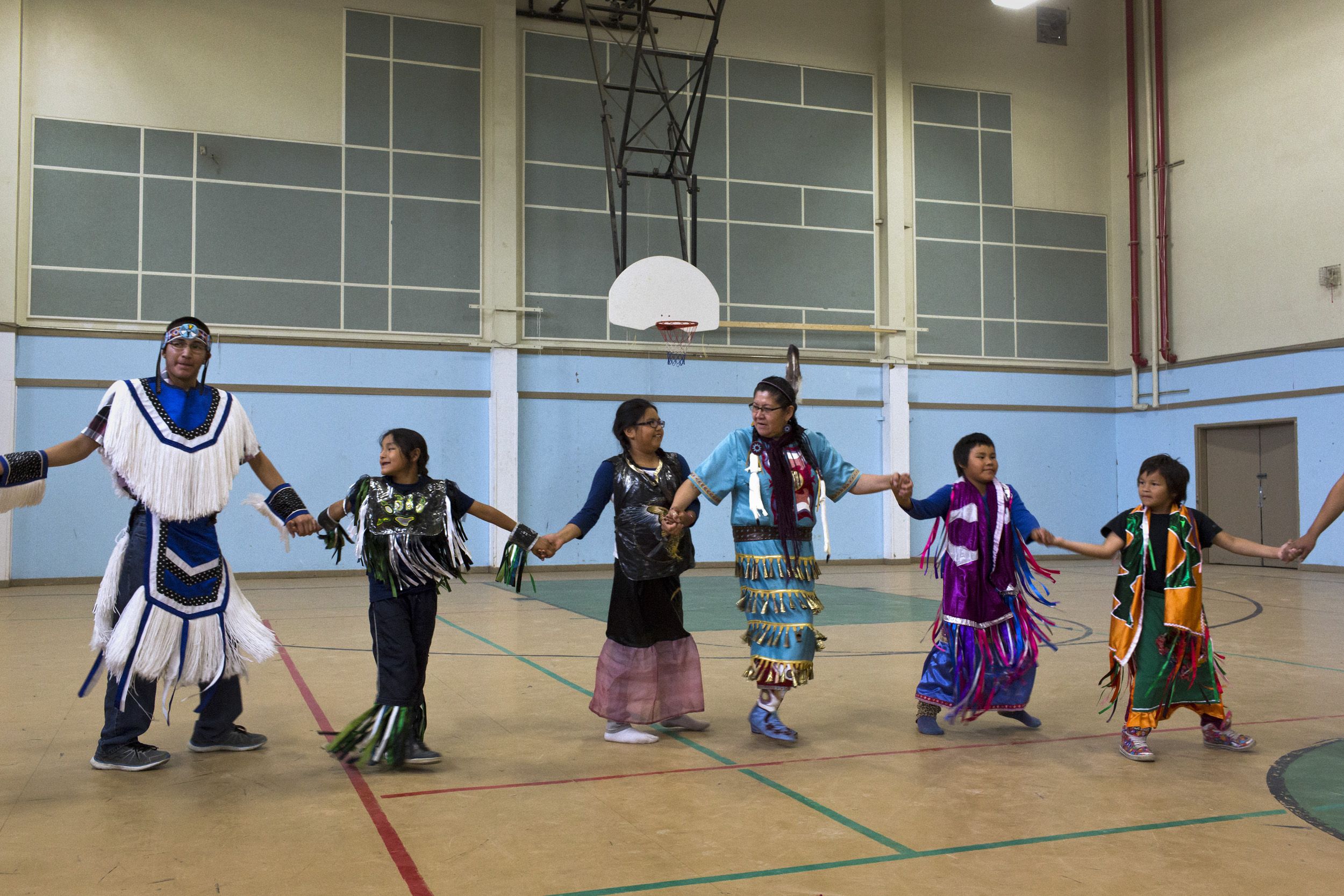 Dancers perform during a ceremony in the Reg Louttit Arena. For many in the community, a return to traditional practices offers a hope for healing. Image by David Maurice Smith/Oculi. Canada, 2016.