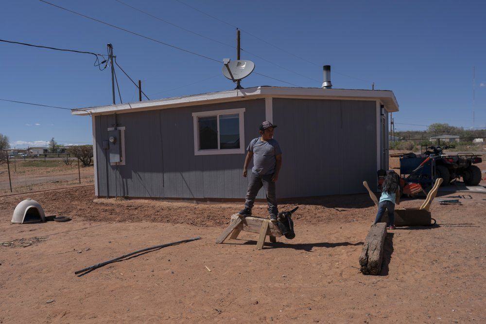 A boy and his sister play in their family compound in Tuba City, Ariz., on the Navajo reservation on April 22, 2020. If Navajos are susceptible to the virus' spread in part because they are so closely knit, that's also how many believe they will beat it. Image by AP Photo/Carolyn Kaster. United States, 2020.