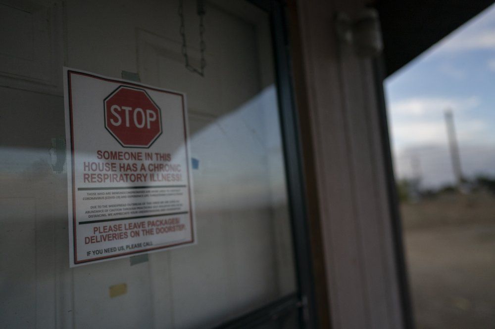A sign is posted on the door of the hogan, a traditional Navajo dwelling, of Mabel Charley's home-bound uncle, to keep visitors out in Chilchinbeto, Ariz., on the Navajo reservation on April 21, 2020. The reservation has some of the highest rates of coronavirus in the country. If Navajos are susceptible to the virus' spread in part because they are so closely knit, that's also how many believe they will beat it. Image by AP Photo/Carolyn Kaster. United States, 2020.