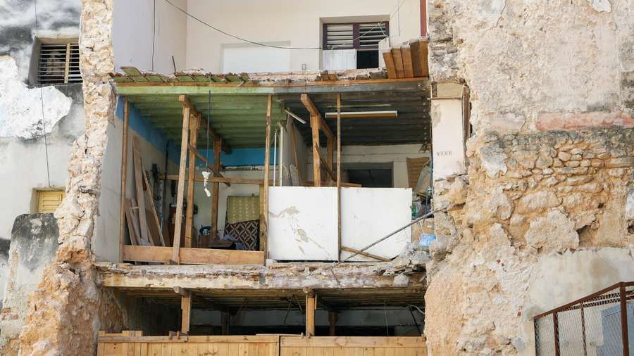 A chunk of Juan Pío Balboa's apartment crashed to the ground. His kitchen and bedroom wall had collapsed, leaving a gaping hole in the building. Image by Tracey Eaton. Cuba, 2019.