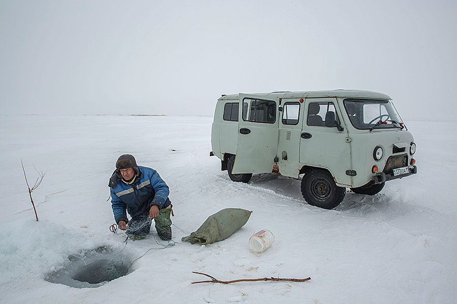 A man uses nets to fish beneath the frozen surface of the Aral Sea near Tastubek. Fishing yields have increased sixfold since 2006. Image by Taylor Weidman. Kazakhstan, 2018.