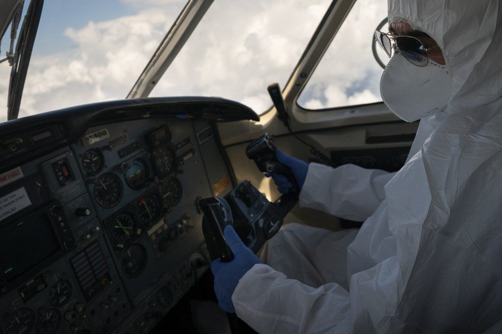 A pilot wearing personal protective equipment airlifts COVID-19 patients from Santo Antonio do Içá to a hospital in Manaus, Brazil, Tuesday, May 19, 2020. Image by AP Photo/Felipe Dana. Brazil, 2020.