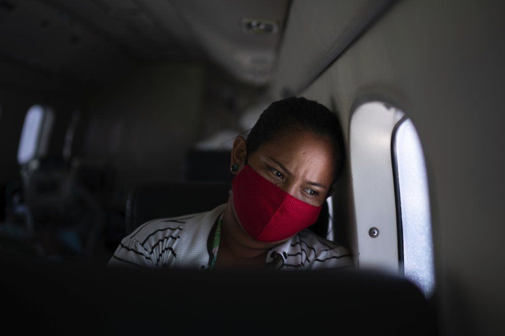 Telma Maria looks out of the window as a doctor monitors her 89-year-old father who is suffering from COVID-19 and is being airlifted from Santo Antonio do Iça to a hospital in Manaus, Brazil, Tuesday, May 19, 2020. Image by AP Photo/Felipe Dana. Brazil, 2020.