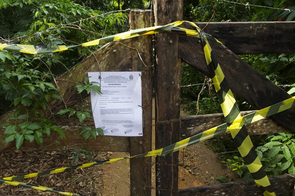 A notice posted to a gate in the village of Córrego da Luz, Brazil, lets visitors know that a trail leading to a waterfall is closed because mosquitoes carrying the yellow fever virus have been detected. The remains of a monkey that died of yellow fever was found near the trail. Image by Mark Hoffman. Brazil, 2017.
