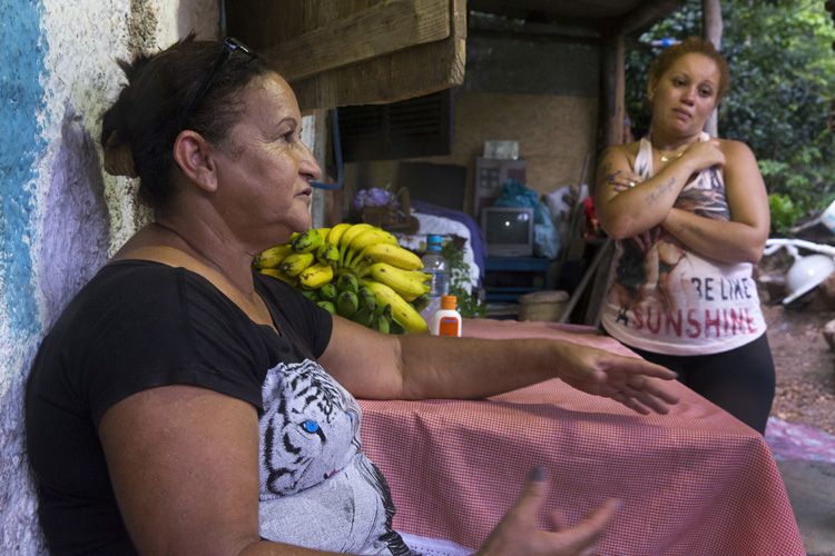 Valdeta Viera dos Santos (foreground) and Dalila de Oliveira Santos share stories about late family member Watila Santos. Image by Mark Hoffman. Brazil, 2017.