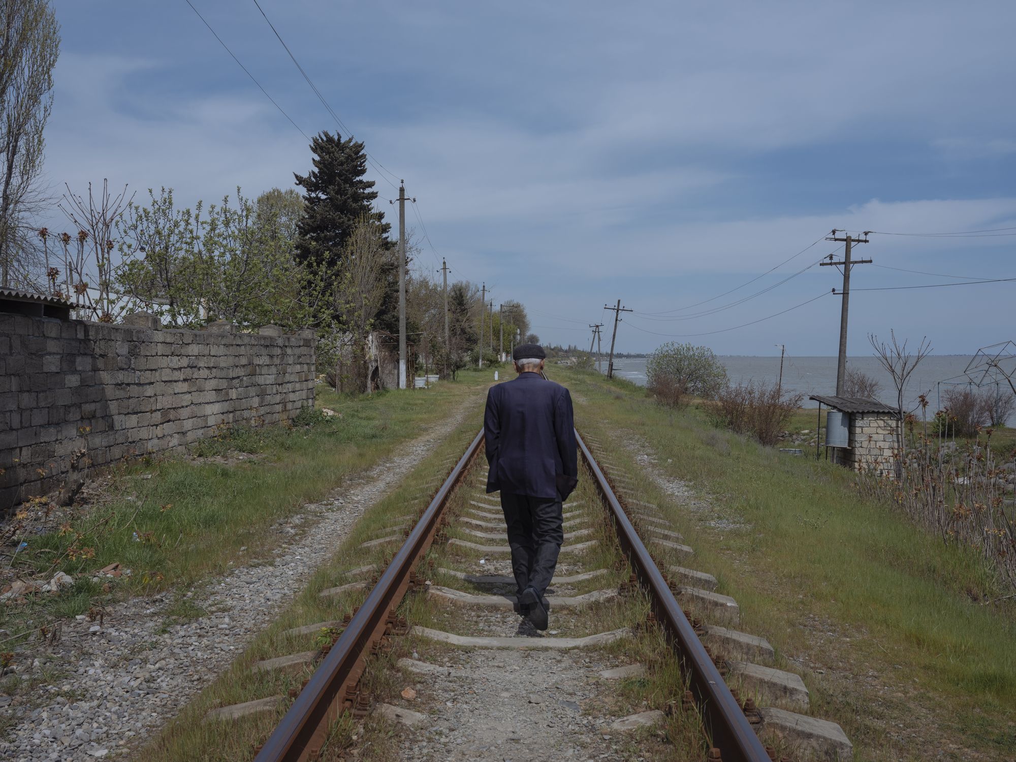 A man walks on railway tracks. Image by Emin Ozmen/Magnum Photos. Azerbaijan, 2018.