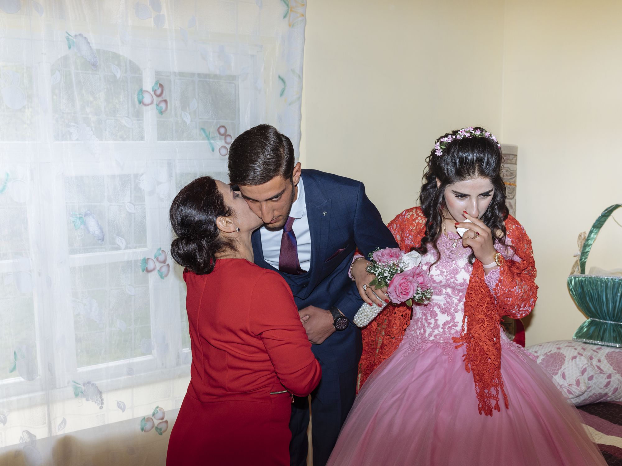 Saray, 48, kisses Muhammed Guliyeva, 20, now the husband of her daughter Terane Sahverdiyeva, 17, before the wedding ceremony in Zarikumecu village. 

In much of Azerbaijan, to be a woman is above all to be a wife and a mother. The priority for women in rural areas is to marry young, because otherwise they will have no alternative but to stay with their parents. Image by Emin Ozmen / Magnum Photos. Azerbaijan, 2018.