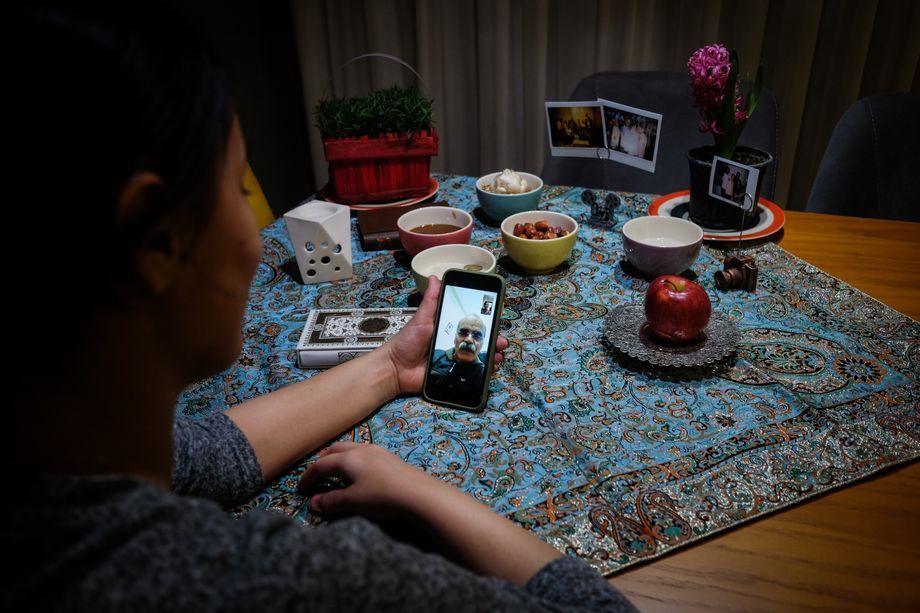 Yasaman Dehmiani, 27, calls her father on the Iranian New Year in March. Her parents live in southern Shiraz and are not allowed to travel to visit their children. Instead, they keep contact via daily video calls. Yasaman, who has a history of respiratory problems, only leaves the house if necessary. Now she is using the quarantine period to spend more time with her husband and catch up on work. Yasaman is part of the team that photographed this series. Image by Mehdi Fazlollahi / NVP Images. Iran, 2020.