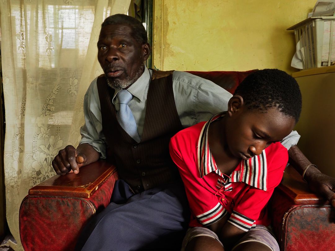 Fostina Kasaila Fostina, 11, a 5th grader. With her is Enoch Kasaila, her grandfather. At 4 years of age, Kasaila started showing signs of lead poisoning including loss of memory and lethargy. Image by Larry C. Price. Zambia, 2017. 