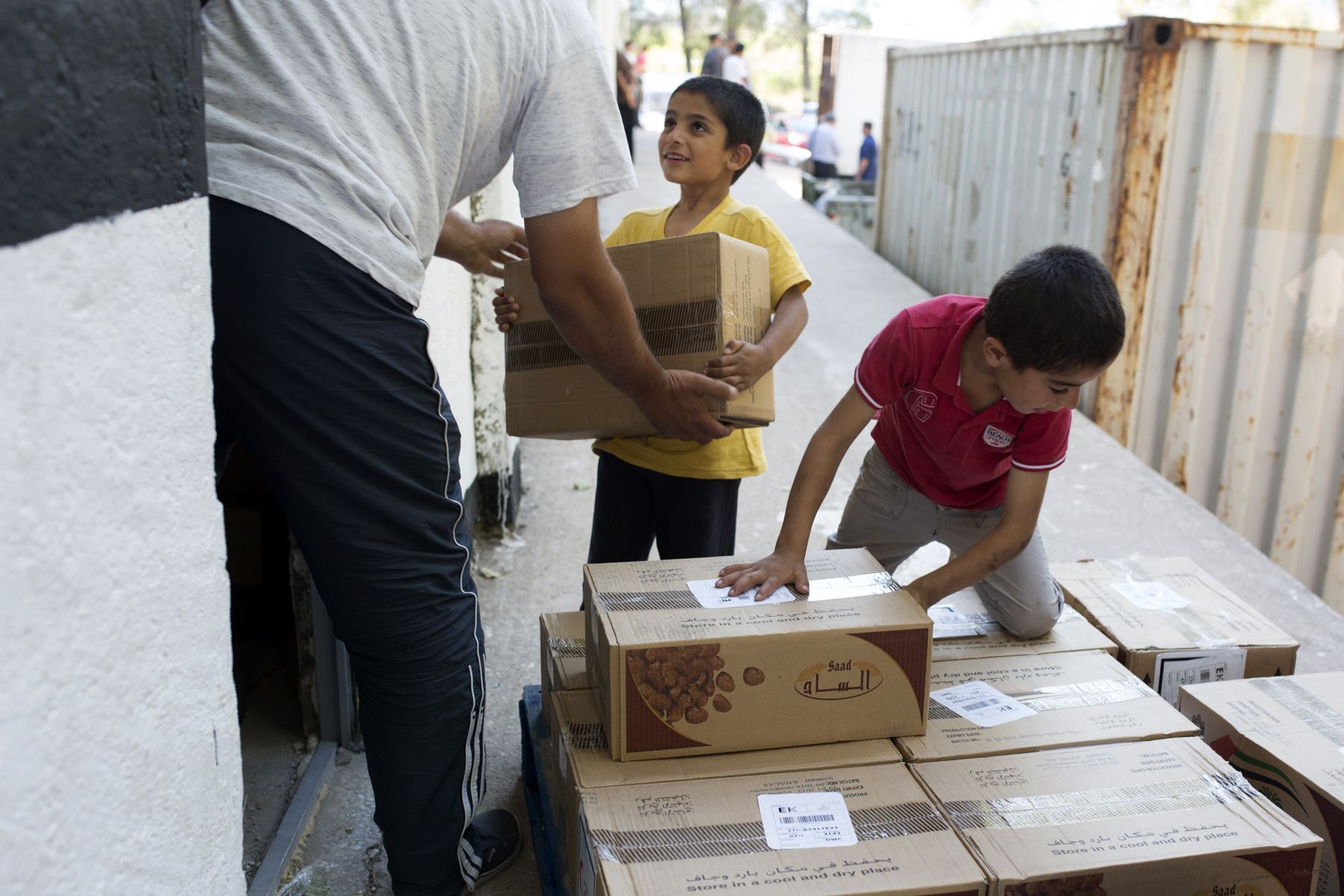 Syrian children help move boxes of dates for Ramadan 