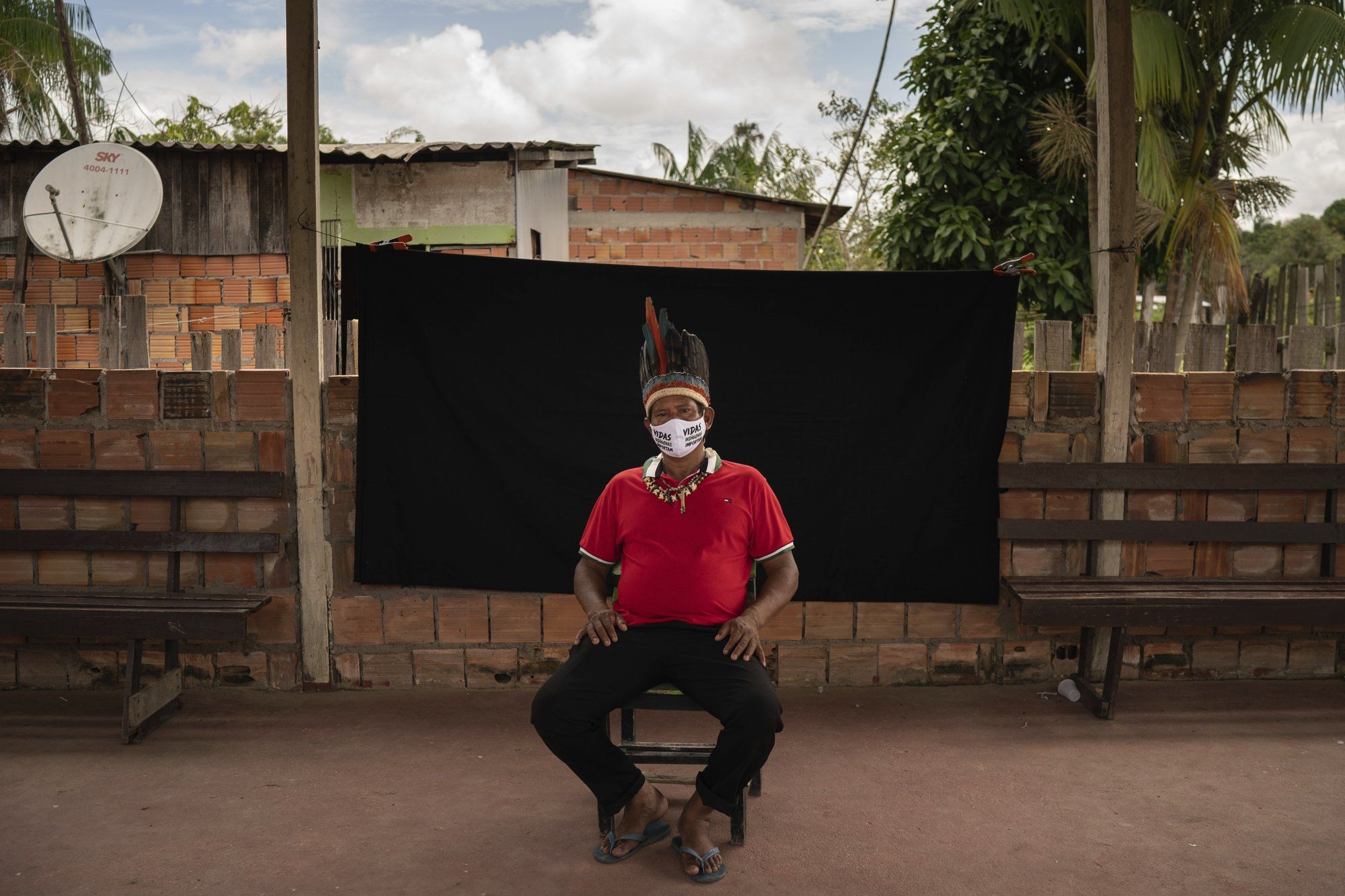 Indigenous leader Jose Augusto, 48, of the Miranha indigenous ethnic group, poses for a portrait wearing a face mask amid the spread of the new coronavirus, at the Park of Indigenous Nations community in Manaus, Brazil, Thursday, May 28, 2020. His mask reads in Portuguese: "Indigenous lives matter." Image by Felipe Dana / AP Photo. Brazil, 2020.
