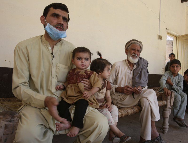 In this May 6, 2020 photo, Tariq Nawaz holds his 10-month-old baby daughter Tuba who suffers from polio, in Suleiman Khel, Pakistan. For millions of people like Nawaz who live in poor and troubled regions of the world, the novel coronavirus is only the latest epidemic. They already face a plethora of fatal and crippling infectious diseases: polio, Ebola, cholera, dengue, tuberculosis and malaria, to name a few. The diseases are made worse by chronic poverty that leads to malnutrition and violence that disrupts vaccination campaigns. Image by AP Photo/Muhammad Sajjad. Pakistan, 2020.