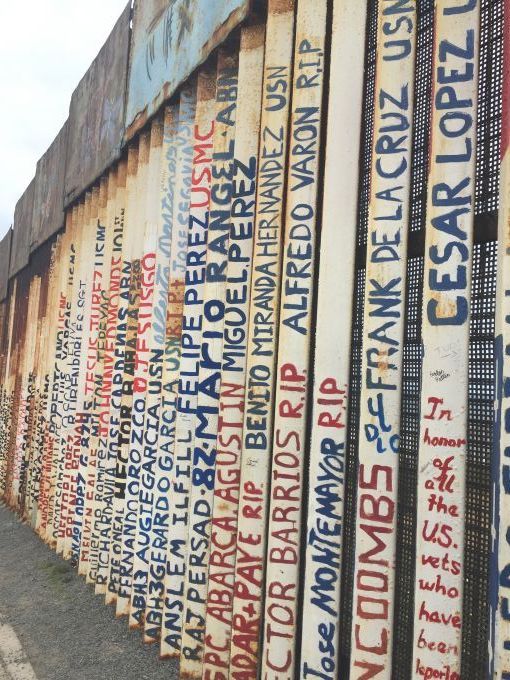 The names of deported veterans were painted in the wall that separates Tijuana, Mexico and San Diego. Image by Maria Ines Zamudio. United States, 2019.