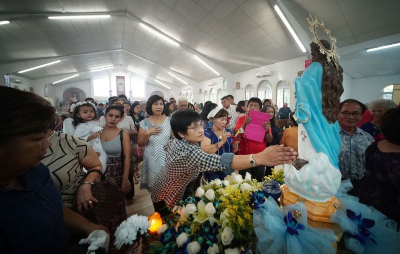 Parishioners pay their respects during a Mass held in honor of the Assumption of Our Lady in Piti, Guam. Image by Cory Lum. Guam, 2017.