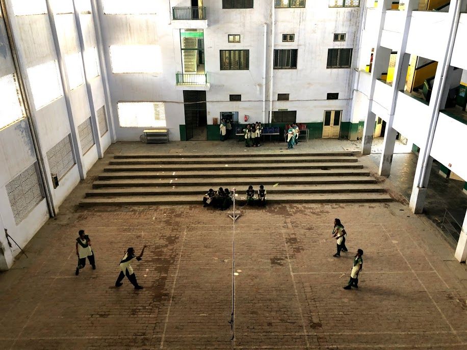 Pardada Pardadi students play badminton in between classes in the school's main hall. Image by Annalisa Merelli. India, 2018.