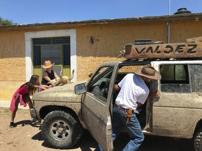 Maya, Joy and Rafael Valdez push their SUV to get it started after the battery died. They use the vehicle in the countryside while sharing the roads. Image by Nina Shapiro / The Seattle Times. Mexico, 2019. 