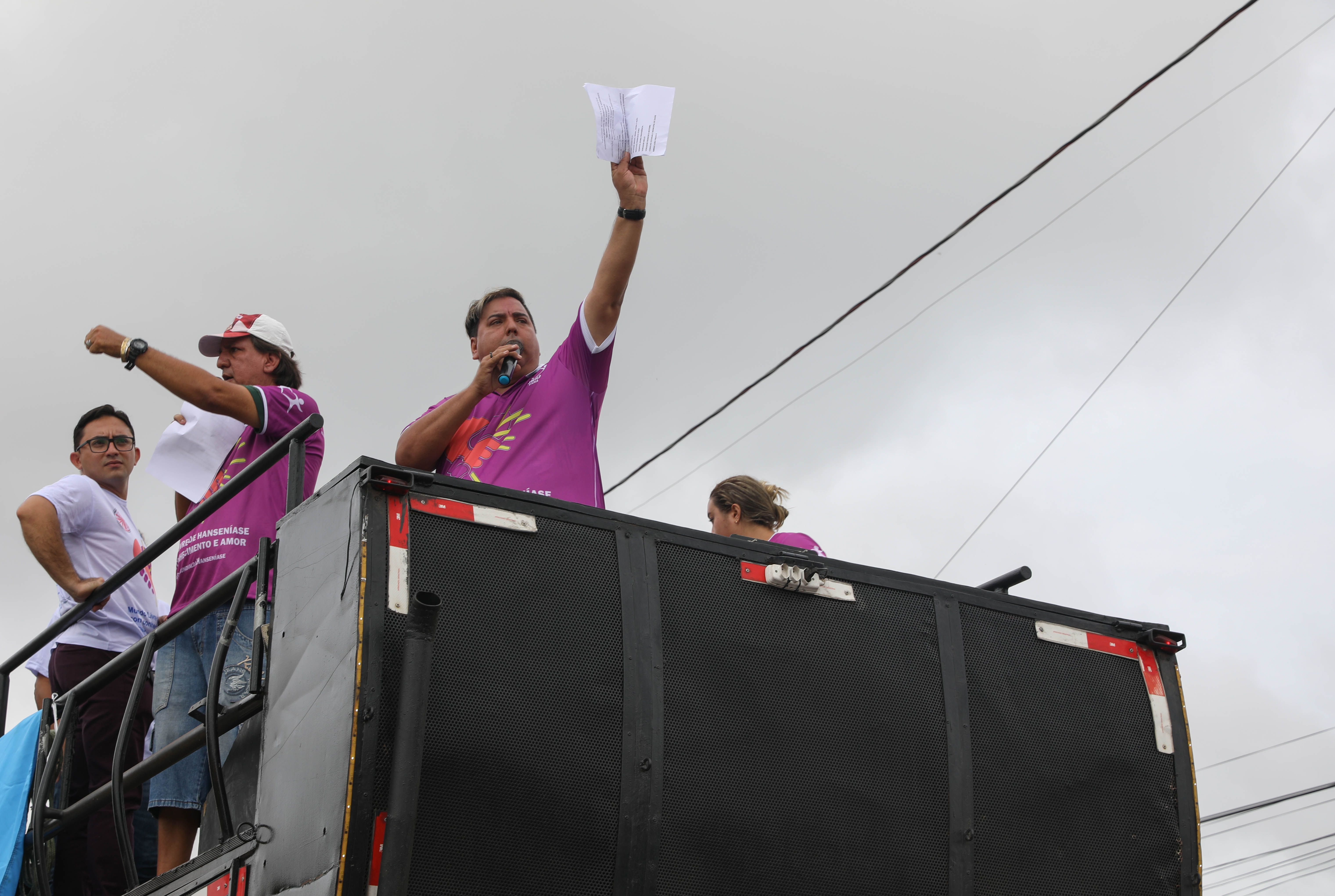 On top of a rally truck, Edmilison Picanco, president of MOHAN in Pará, signals his fellow volunteers during a leprosy awareness march in Marituba. Image by Anton L. Delgado. Brazil, 2020.