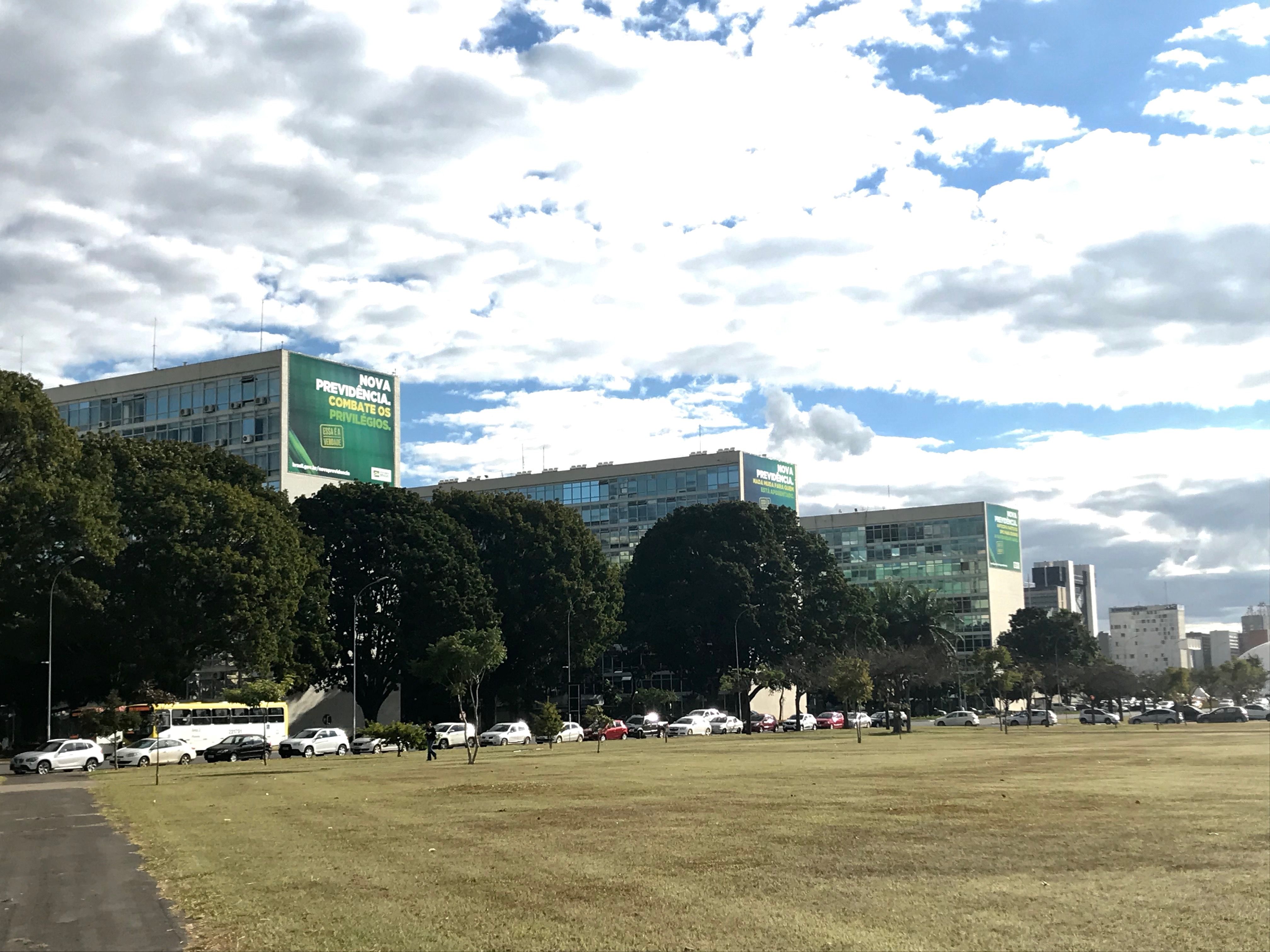 As part of an unprecedented marketing strategy, the government under Bolsonaro decided to put billboards showing the benefits of their unpopular social security reform in front of each ministry building. This is the first time in Brazil’s history that the ministries were used for marketing purposes. Image by Rafael Lima. Brazil, 2019.