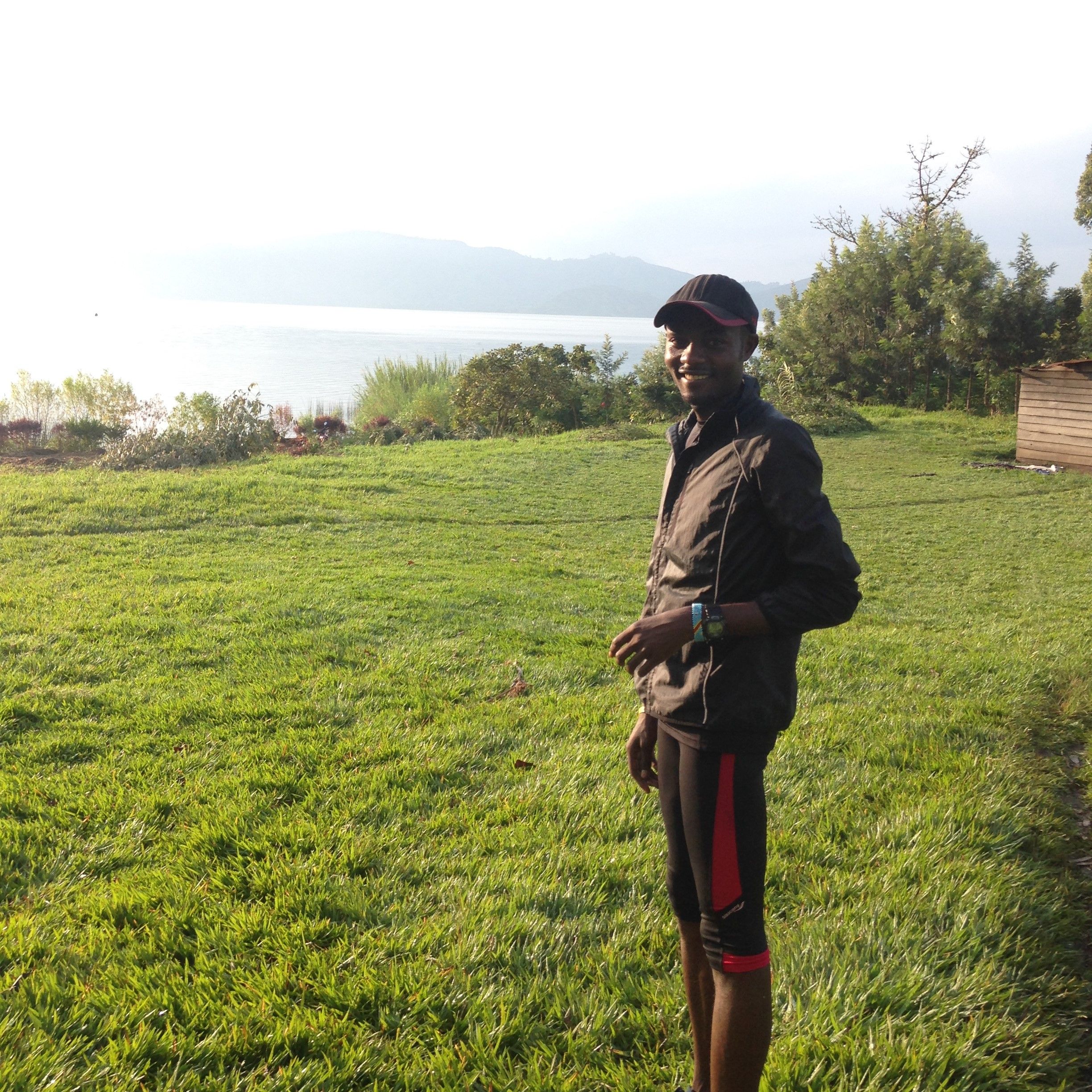 Dee stands on the shore of Lake Kivu as the sun comes up after early morning practice.