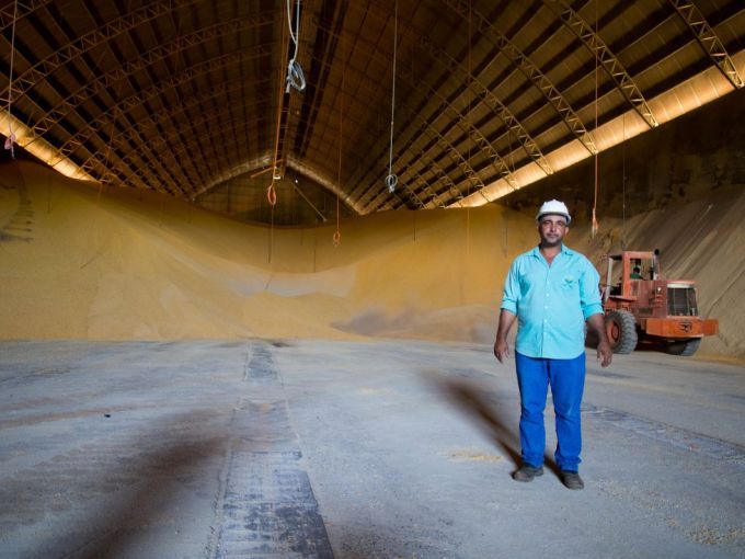 In Sinop, a laborer shows an enormous grain repository, where soy and corn are stored in temperature—and humidity—controlled conditions to gradually be transported by truck and then exported. Image by Heriberto Araújo. Brazil, 2019.