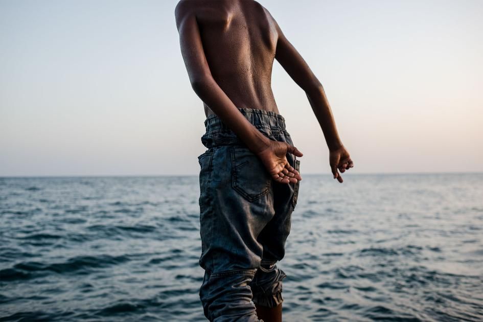Musa prepares to jump in the water after his family's fishing trip. The group failed to catch any fish and returned to shore to retie their nets for the next day's excursion. Image by Alex Potter. Yemen, 2018.