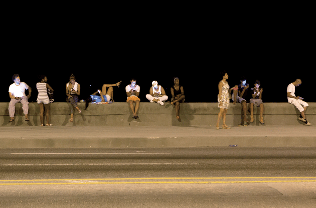 Cubans using Wi-Fi on the Malecón, in one of the fifty-three Wi-Fi zones in Havana. Image by Alexa Hoyer. Cuba. 
