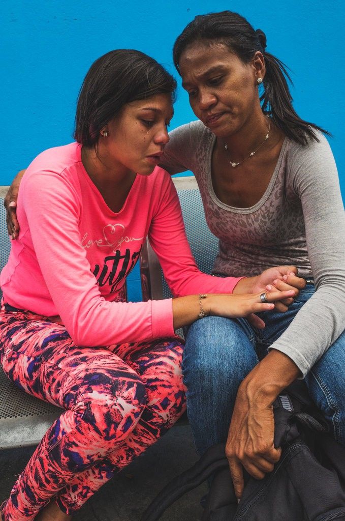Yaneidi Nazaret, 17, cries besides her mother, who was charged 50 Bolivares to enter La Yaguara Detention Center, Caracas, to visit her daughter and bring her food. Image by Ana María Arévalo. Venezuela, 2018. 