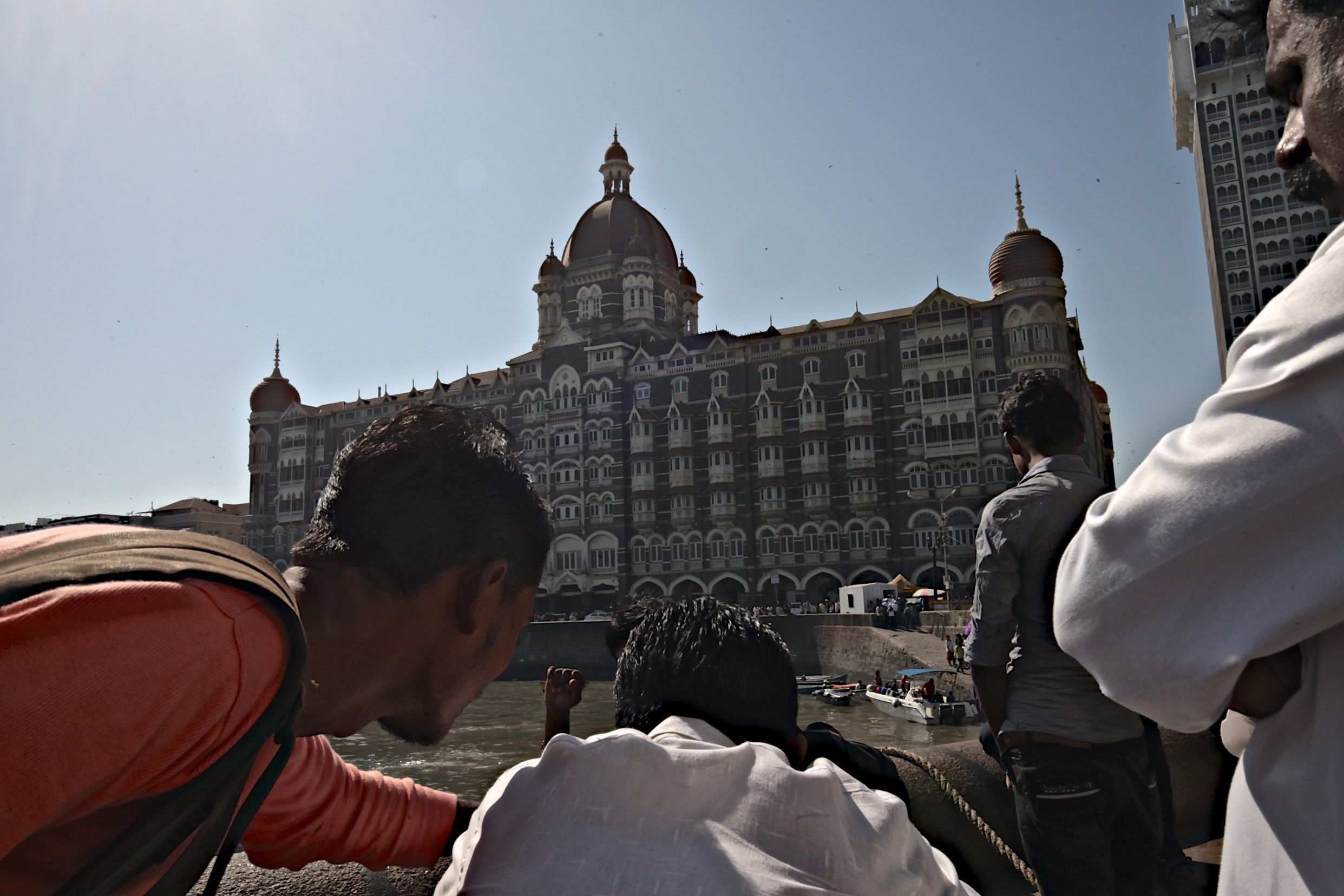 Indian men take pictures near the Taj Mahal hotel, one of the targets of the 2008 terrorist attack. Image by Wes Bruer. India, 2017.