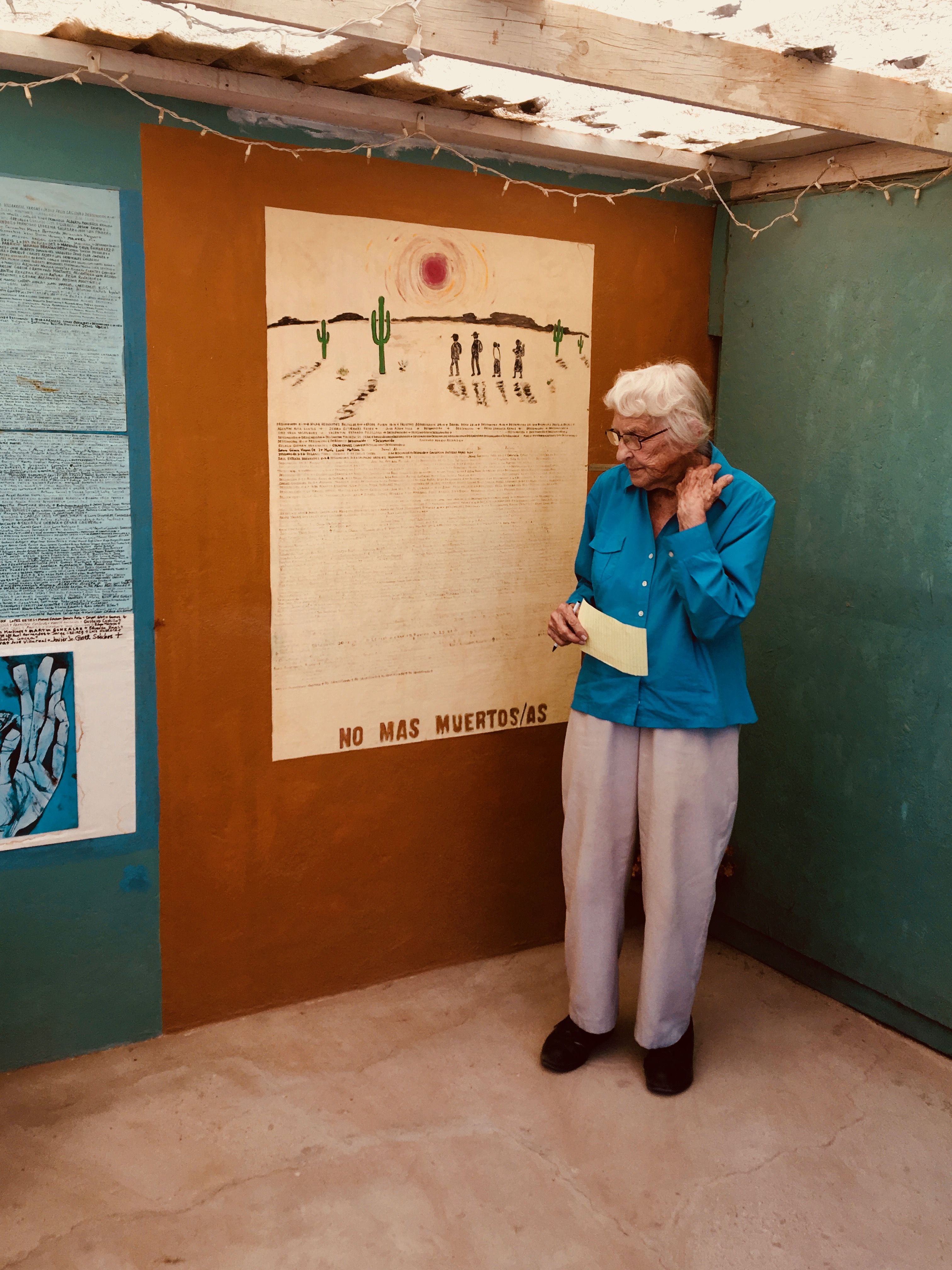 Campbell speaks to a “border immersion” group in her backyard shrine. When Americans come to Juárez on educational trips, they often stop at Campbell’s house, Casa Tabor. She leads a discussion about foreign policy inside and then takes her visitors out to the shrine, where she hands each person a Sharpie and a paper slip with a new name to write on the wall. Image by Lily Moore-Eissenberg. Mexico, 2019.