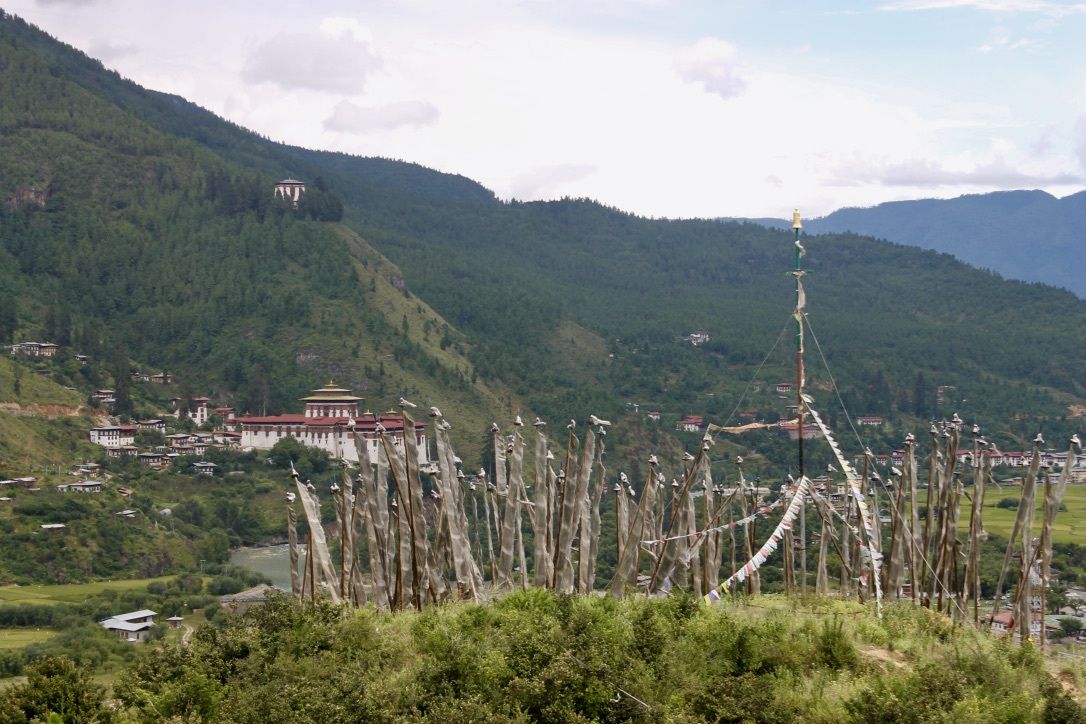 A view of prayer flags and the Paro dzong, or fortress, in Paro, Bhutan. Image by Emma Johnson. Bhutan, 2019.