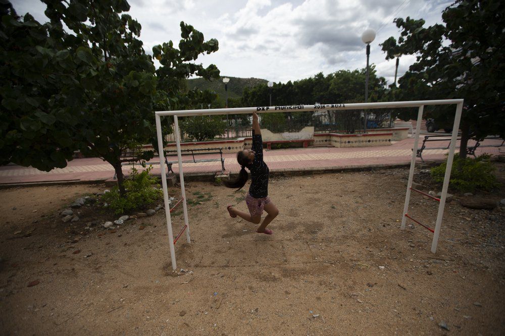 A girl plays at the park in San Jeronimo Xayacatlan, a town in Mexico from where nearly a third have emigrated to New York, Thursday, June 25, 2020. Mexicans fear for their relatives in the north, watching from afar as they lose their jobs, fall sick from the new coronavirus alone or without the documents that would allow them to move around freely -- and, too often, die in a foreign land. Image by Fernando Llano/AP Photo. Mexico, 2020.