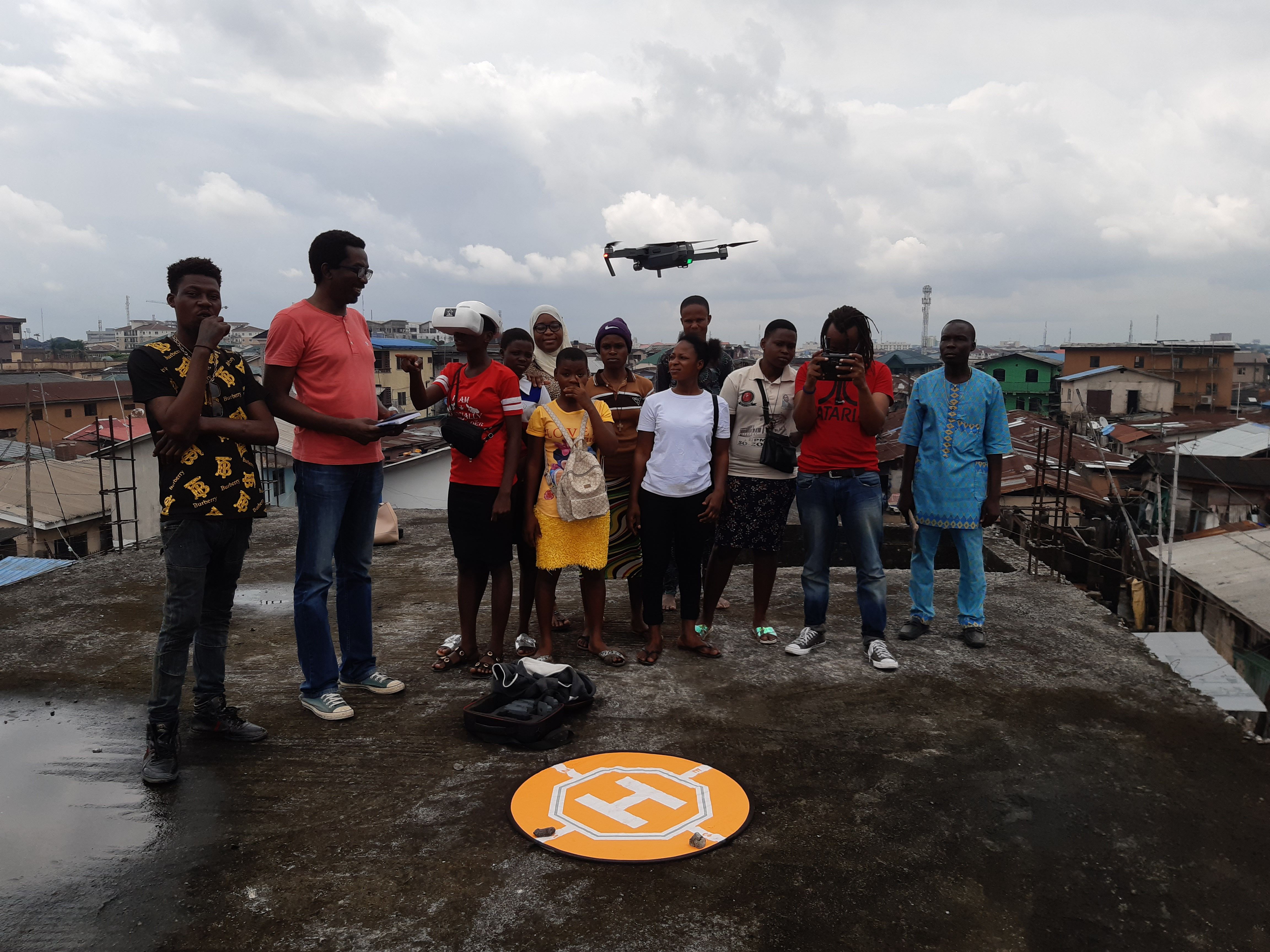 A team of drone pilots (Ferderick Mubaya, Khadija Ali - both from UhuruLabs and Ayo Akinseye) supporting young female pilots on modern mapping techniques to aid them map their community in Makoko, Lagos, Nigeria. Image courtesy of UHURULABS / Code for Africa. Nigeria, 2019.