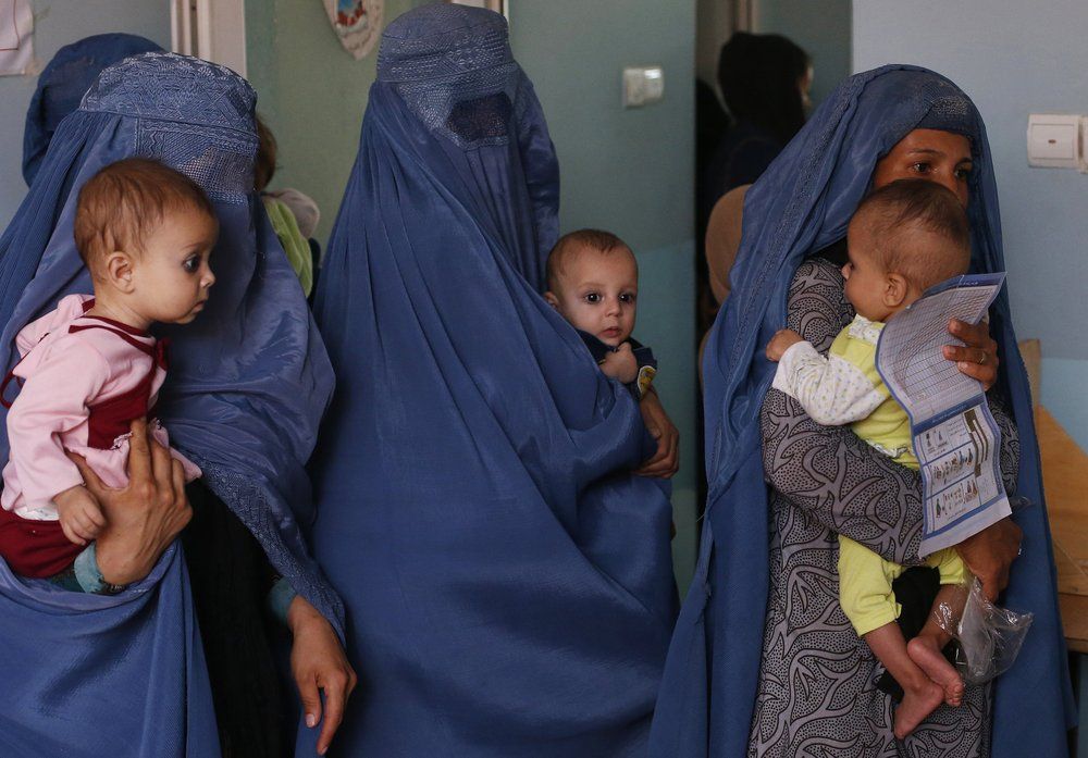 FILE - In this Aug. 26, 2019 photo, mothers hold their babies suffering from malnutrition as they wait at a UNICEF clinic in Jabal Saraj, north of Kabul, Afghanistan. In Afghanistan, severe childhood malnutrition spiked from 690,000 in January 2020 to 780,000 — a 13% increase, according to UNICEF. Food prices have risen by more than 15%, according to the World Food Program. Image by Rafiq Maqbool/AP Photo. Afghanistan, 2019.