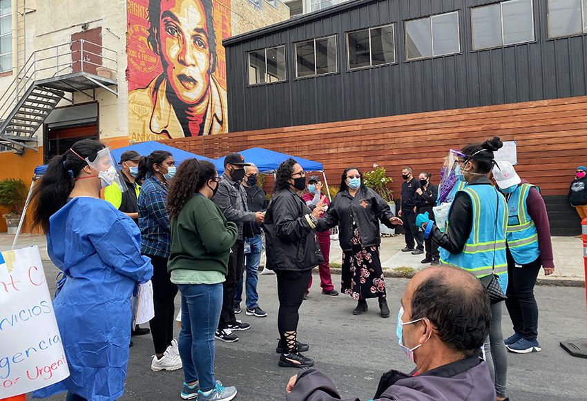 The Latino Task Force leaders—Jon Jacobo in the cap, Susana Rojas and Tulier-Laiwa in the front—briefing volunteers and workers on testing protocol at the Thursday mobile site. Image by Lydia Chávez. United States, 2020.