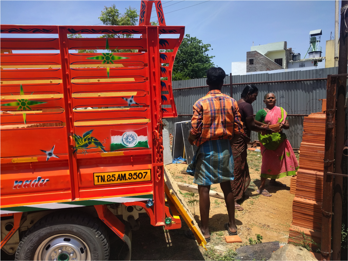 Workers at Shakthi Ganga lift materials into a lorry. The man will be paid 320 rupees, while the women will be paid 160 rupees each. Image by Praveena Somasundaram. India, 2017.