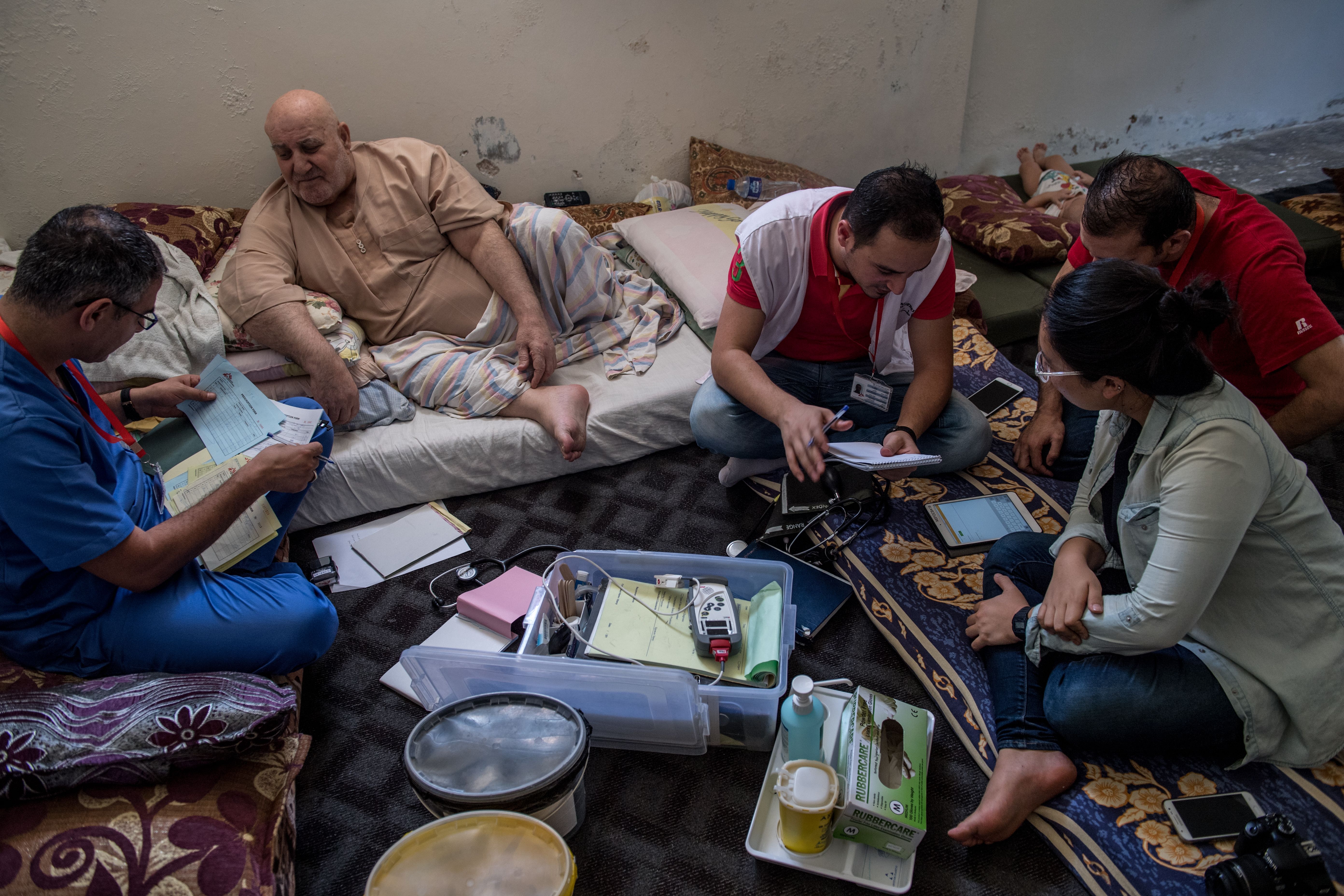 A doctor from Médecins Sans Frontières speaks with Ibrahim Hassan, a Syrian refugee living in Northern Jordan. Staff from the Dharma Platform collect information and prepare to deploy new data-collection technology along the Syrian border. Image by Neil Brandvold. Jordan, 2017.