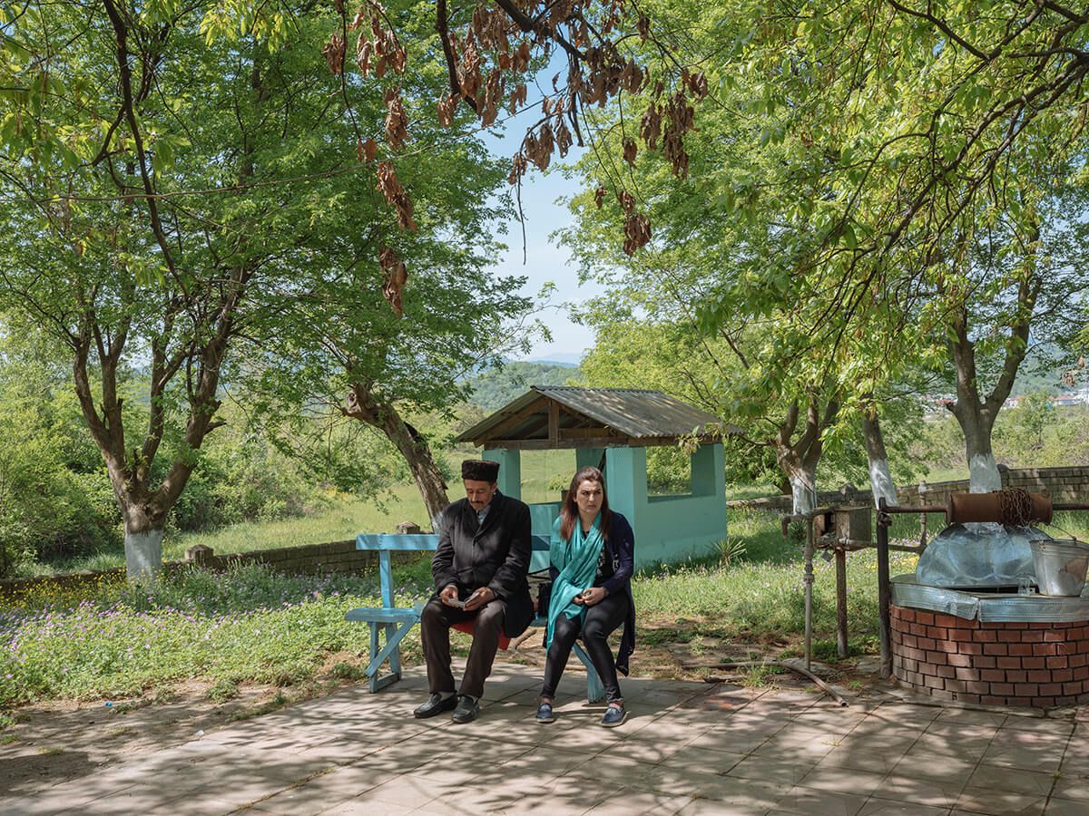 A man and a woman sit outside the Seydi Pir mausoleum in the Shaglakuche village, near Lankaran. Most Talysh people are Shia Muslim. Image by Emin Özmen/Magnum Photos. Azerbaijan, 2018.