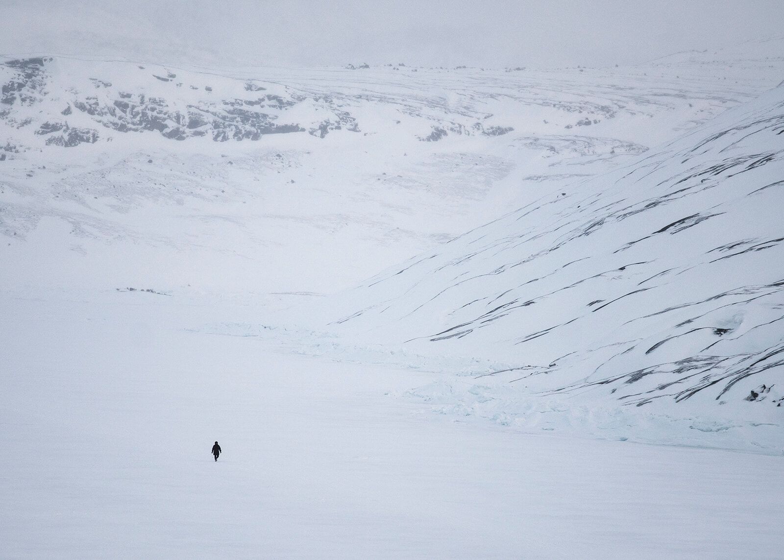 A woman takes her daily walk across the frozen bay next to Oqaatsut. Image by Jonas Bendiksen/Magnum Photos. Greenland, 2018.