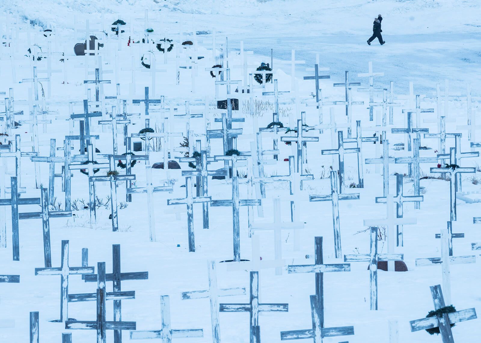 Crossees in a cemetery in Nuuk. Greenland has one fo the highest rates of suicide in the world, which researchers attribute in part to the fact that many people have difficulty finding their place at the crossroads of traditional and modern lifestyles. Image by Jonas Bendiksen/Magnum Photos. Greenland, 2018.