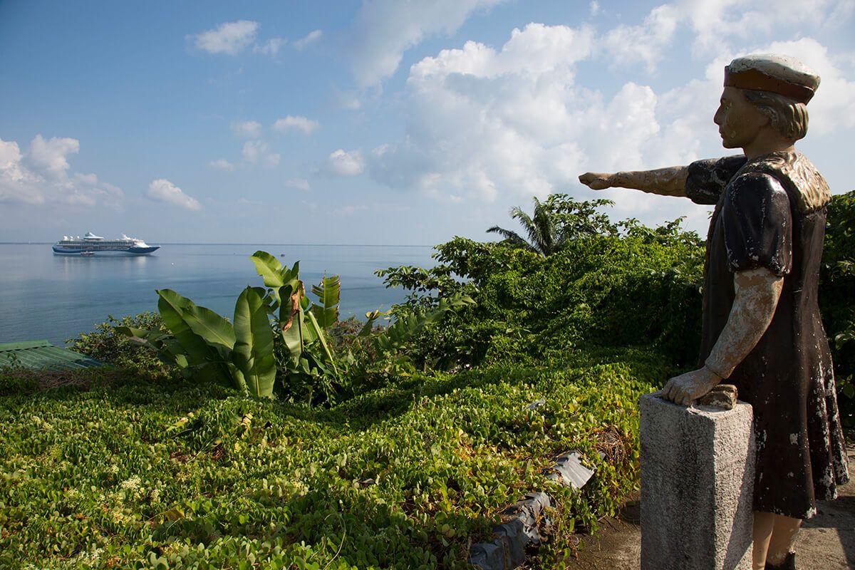 A statue of Christopher Columbus on a lookout in Trujillo points to the spot where the explorer first landed on mainland Central America. Image by Susan Meiselas/Magnum Photos. Honduras, 2018.