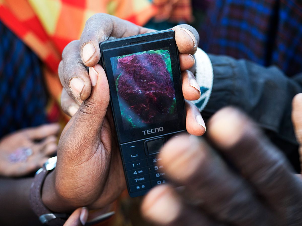 Local collectors look at images of rubies on a cellphone. Image by Thomas Dworzak/Magnum Photos. Tanzania, 2018.