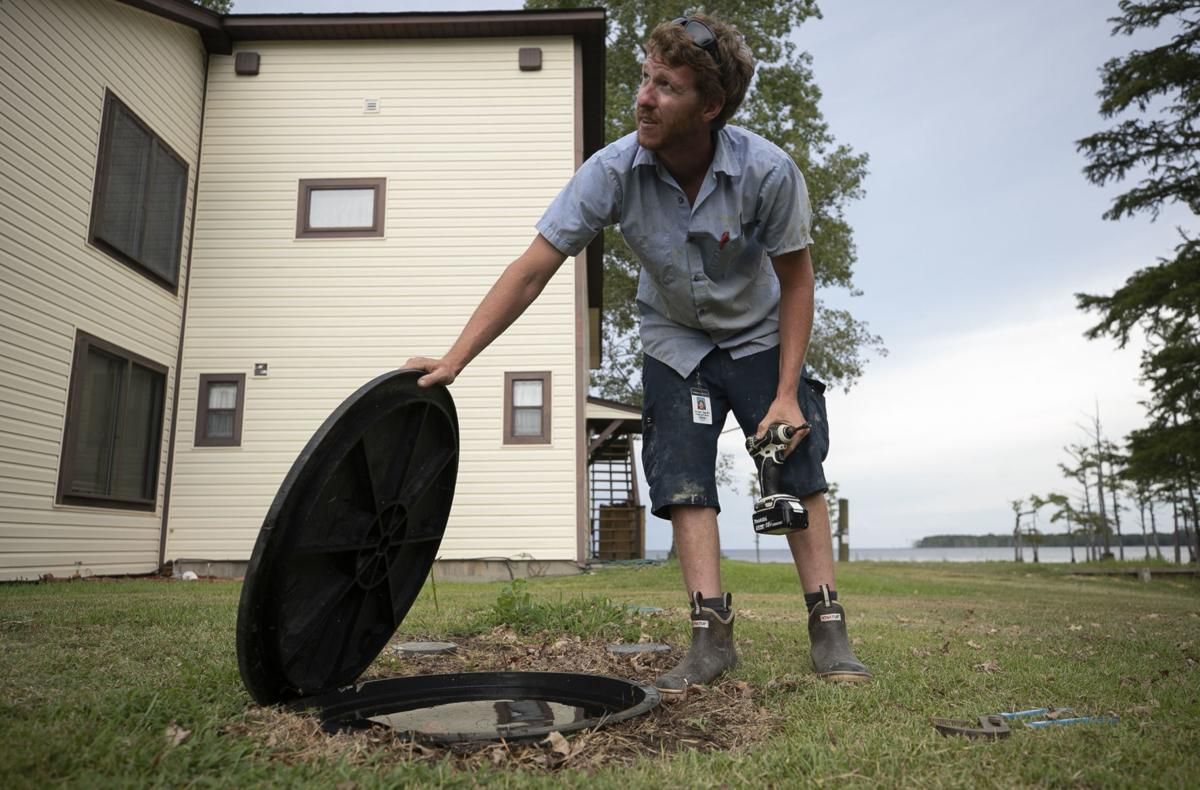 Jordan Sexton, a Tyrrell County Water/Sewer Department employee, works to find the cause of a water leak at a home on Folly Landing Road on Thursday, July 23, 2020. Image by Robert Willett / The News & Observer / North Carolina News Collaborative. United States, 2020.