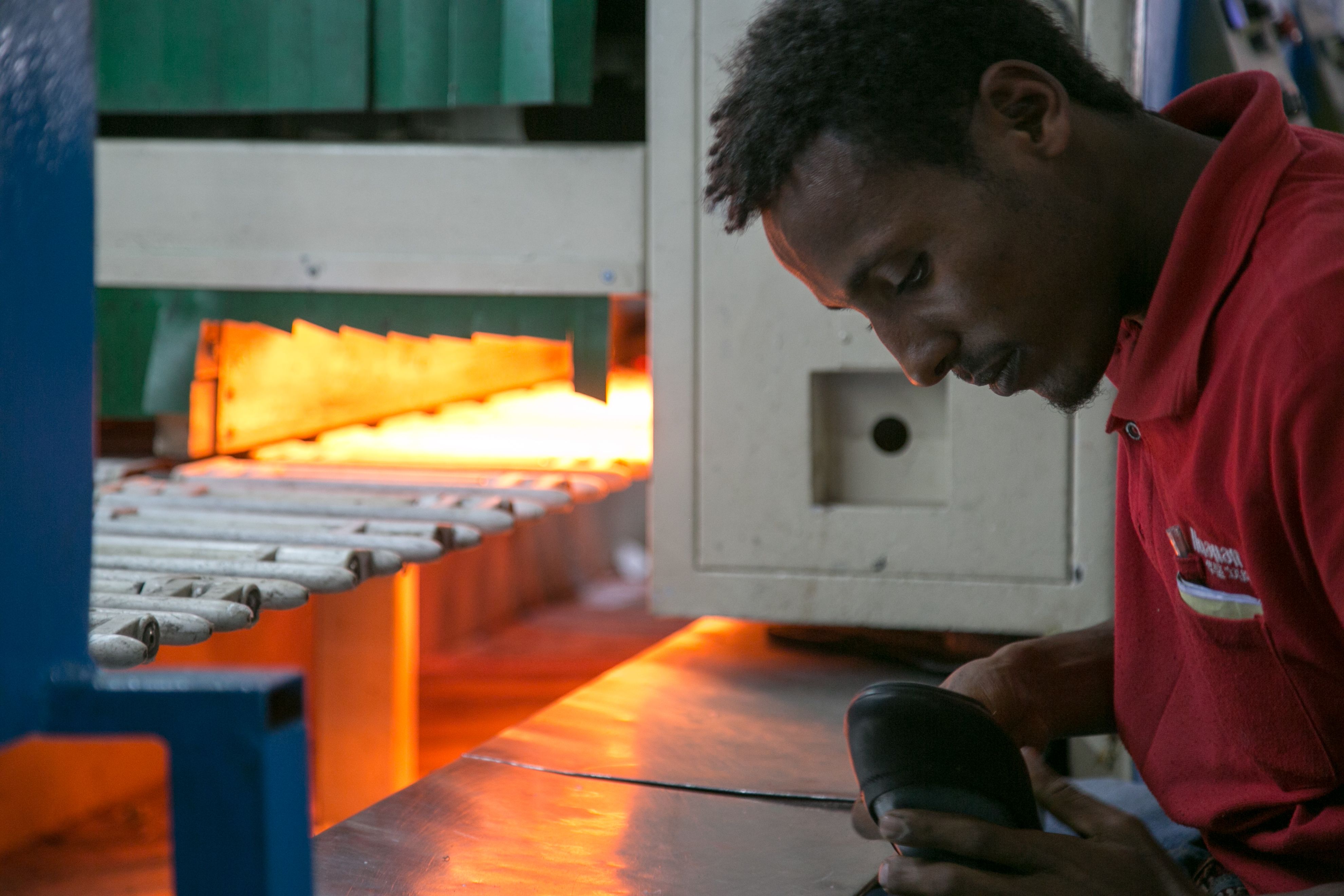 An Ethiopian worker constructs a shoe on the Huajian assembly line. Image by Noah Fowler. Ethiopia, 2017.