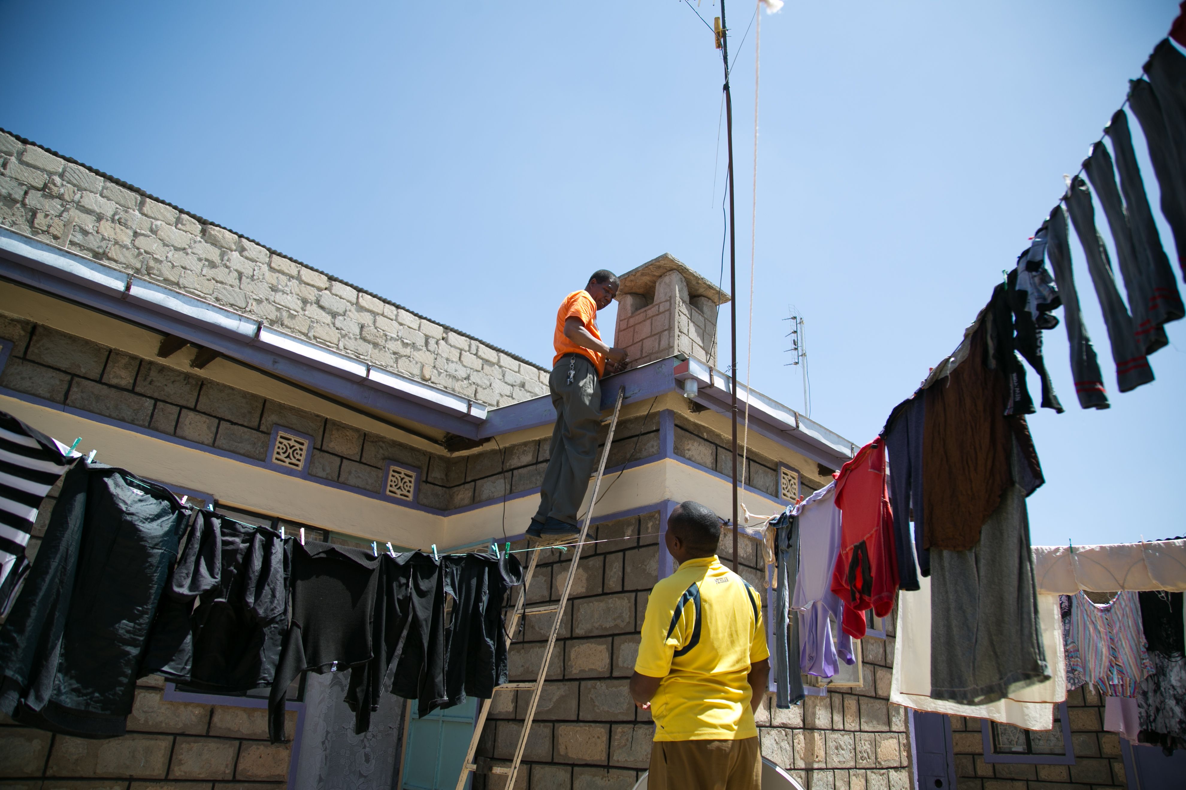 David Mugita installs a satellite dish on a customer’s roof in Kajiado. Image by Immanuel Muasya. Kenya, 2017.