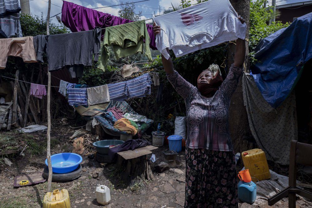 Mother of two Amsale Hailemariam, a domestic worker who lost work because of the coronavirus, hangs clothes after washing them outside her small tent in the capital Addis Ababa, Ethiopia on Friday, June 26, 2020. The virus arrived, and dreams faded for families, and entire countries. The world could see its first increase in extreme poverty in 22 years, further sharpening social inequities. Image by AP Photo/Mulugeta Ayene. Ethiopia, 2020.