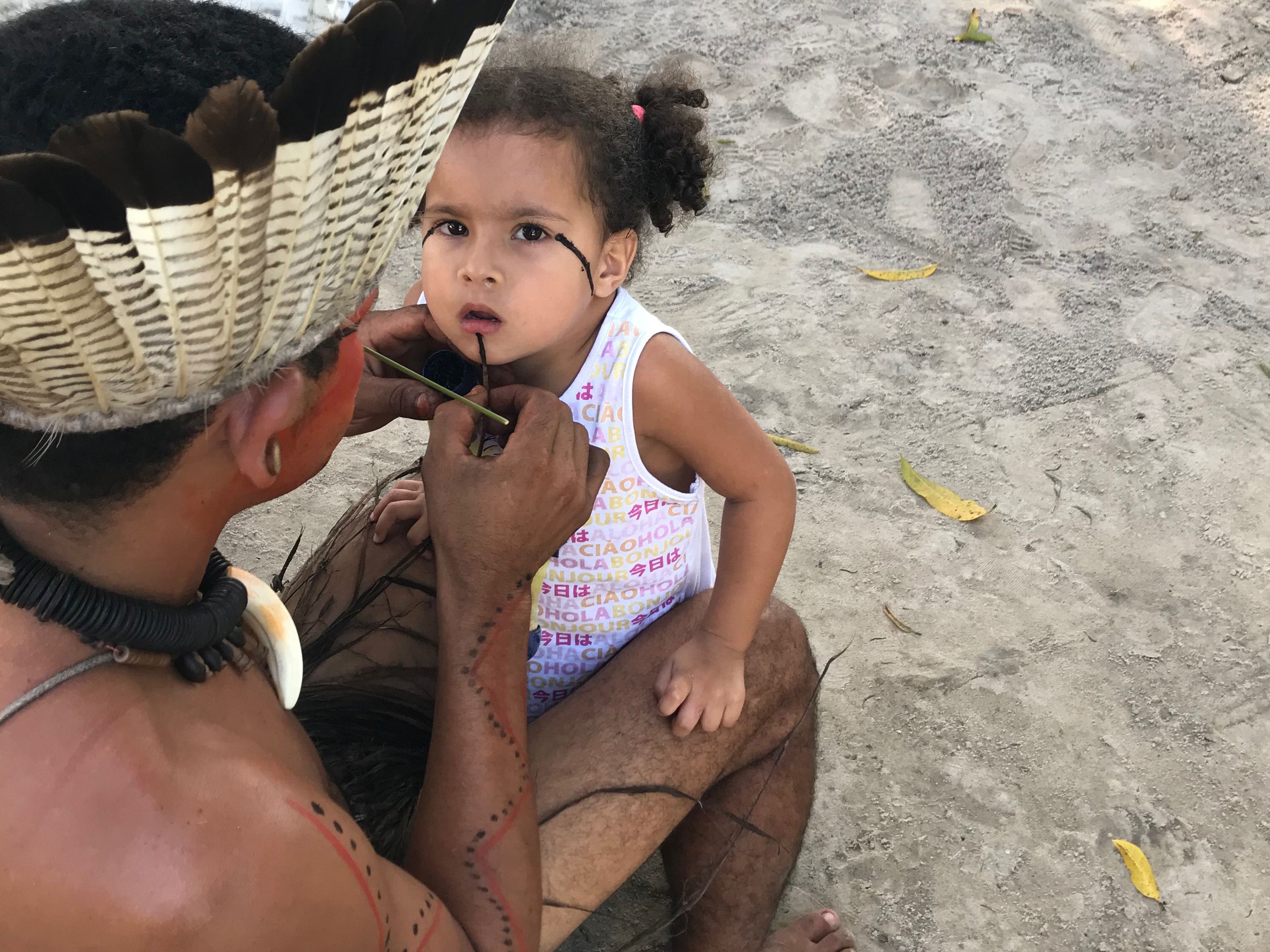 Mucunã (father) painting his daughter Micaela in preparation for a dance. Strong colors like black are reserved for times of battle and resistance among the Potiguaras of Catu. Image by Rafael Lima. Brazil, 2019.
