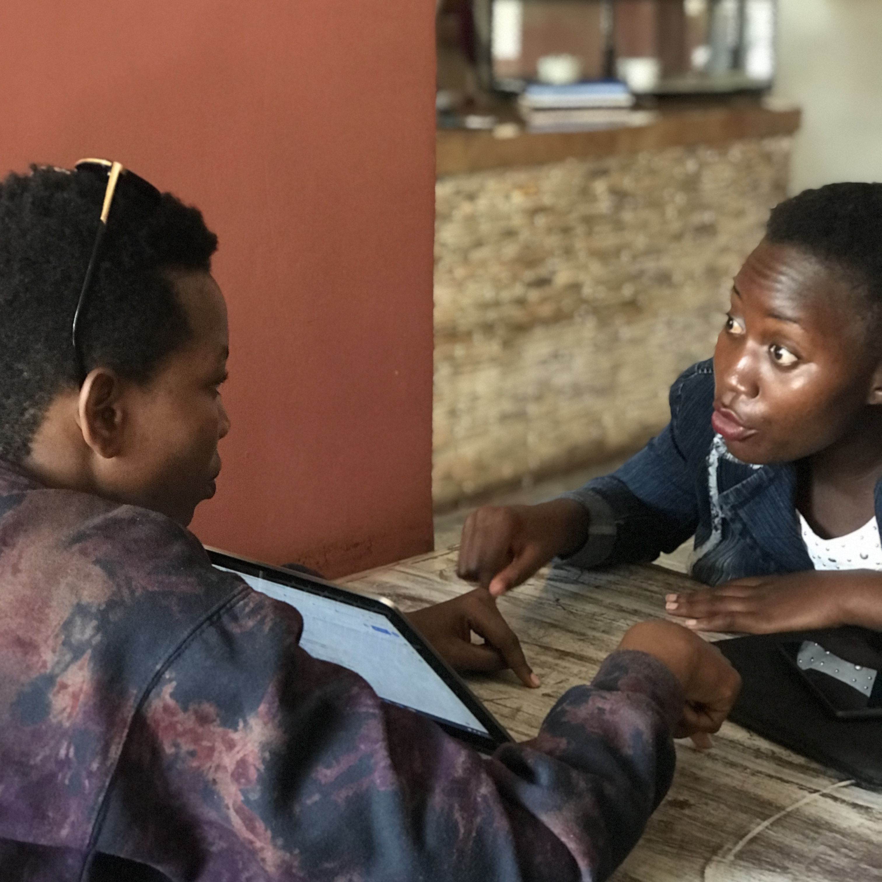 Betty Benjamin (left) and Nakaziba Sumaya, two members of the GIRLY network team, receive word of a case of sexual violence in Iganga and discuss how to best support the victim. Image by Keishi Foecke. Uganda, 2019.