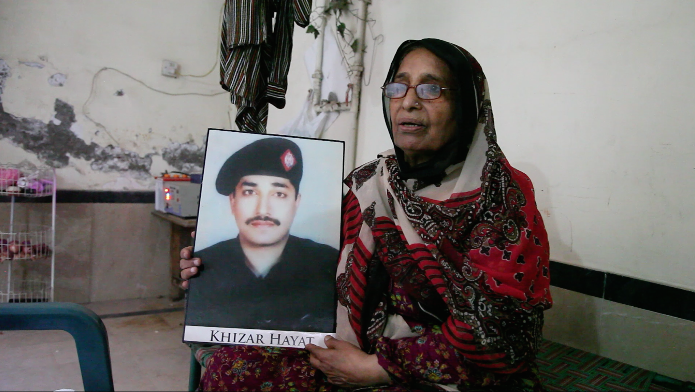 Iqbal Bano holds a photo of her son who is currently on death row in Lahore Central Jail.